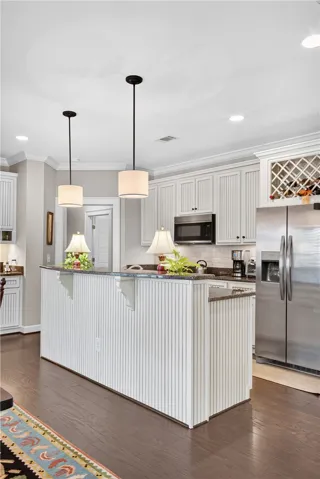 Elegant kitchen boasts sleek stainless steel appliances and rich hardwood flooring, ready for your culinary adventures.