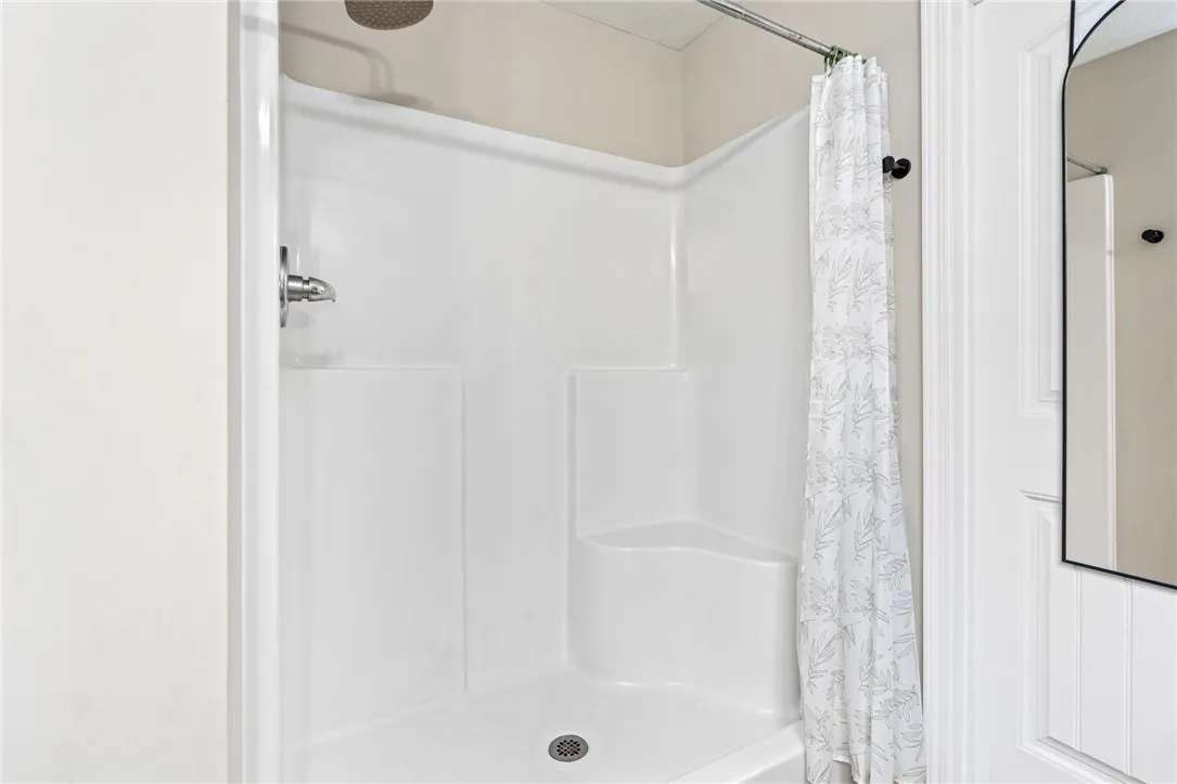 A well-maintained shower stall with a built-in seat offers comfort and convenience.