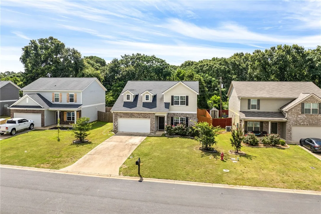 A classic two-story home with a brick and siding exterior and a well-maintained front yard.