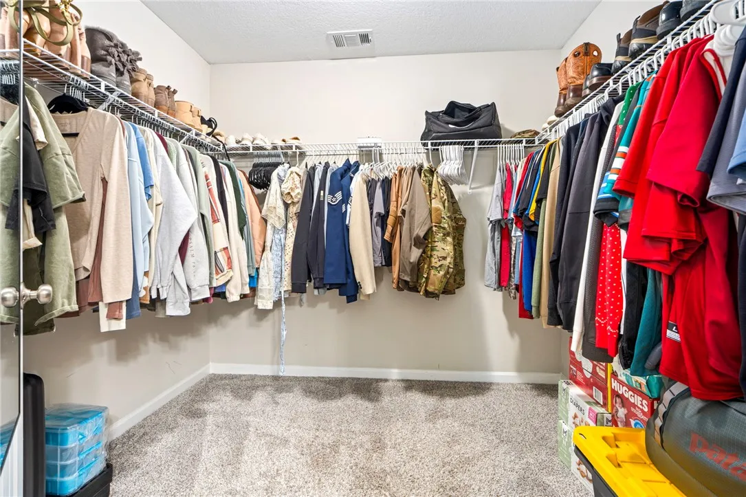 Walk-in closet with ample wire shelving and plush carpeting for comfortable storage.