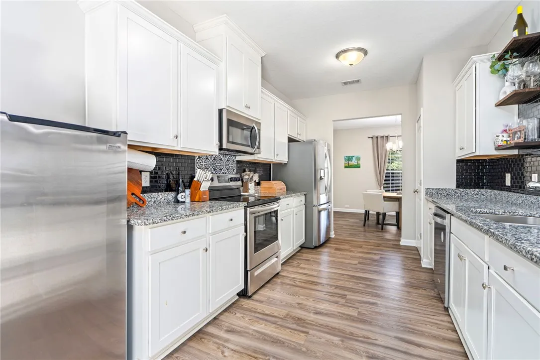 A well-appointed kitchen features ample counter space, bright cabinetry, and modern stainless steel appliances.