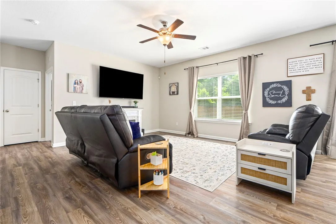 A comforting living room featuring durable wood flooring and ample natural light through a generous window.