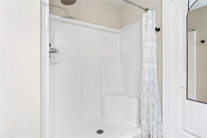 A well-maintained shower stall with a built-in seat offers comfort and convenience.