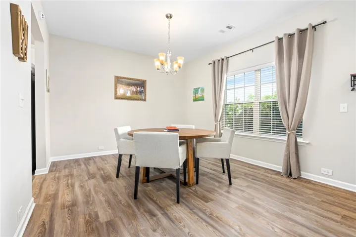 Hardwood-style flooring and abundant natural light create an inviting dining experience.