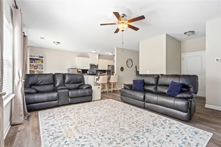 An inviting common area combines living and kitchen spaces, featuring rich wood-look flooring.