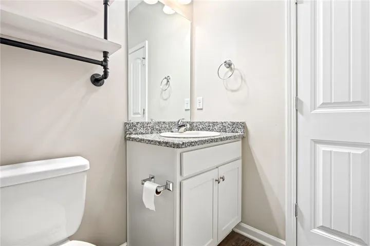 A compact powder room with a sleek vanity and modern fixtures.