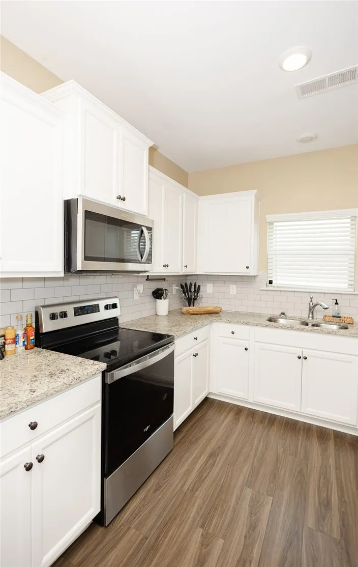 Culinary aspirations come alive in this kitchen featuring abundant cabinetry and sleek countertops.