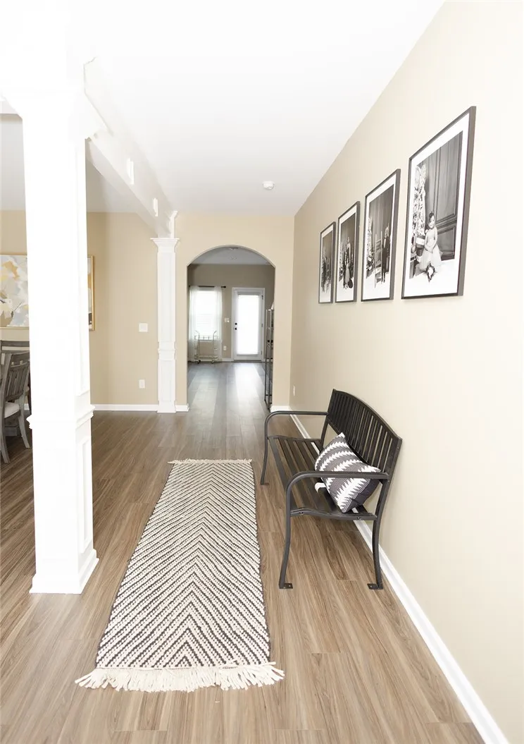 Columned architectural features define this welcoming entry with wood​​‌​​​​‌​​‌‌​‌‌​​​‌‌​‌​‌​‌​​​‌​​ flooring.