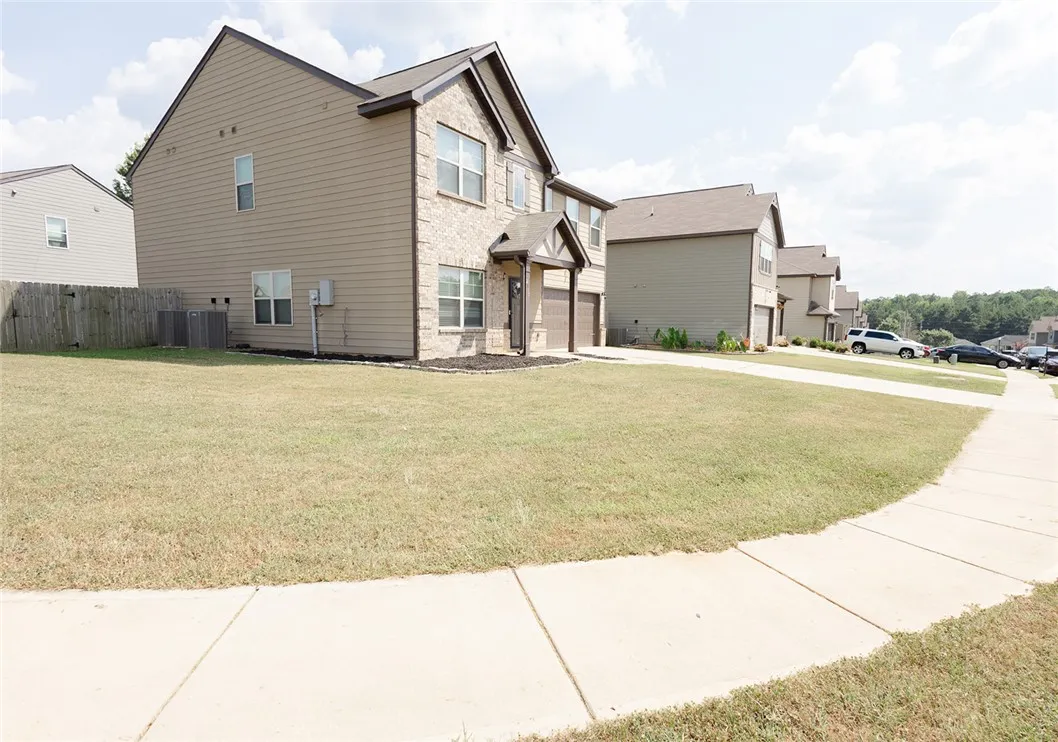 A classic brick and siding two-story home, with a neatly maintained front lawn and attached garage, awaits.