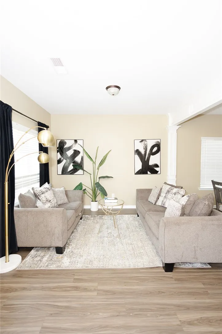 A well-lit sitting area with durable wood-look flooring and a light-toned rug.