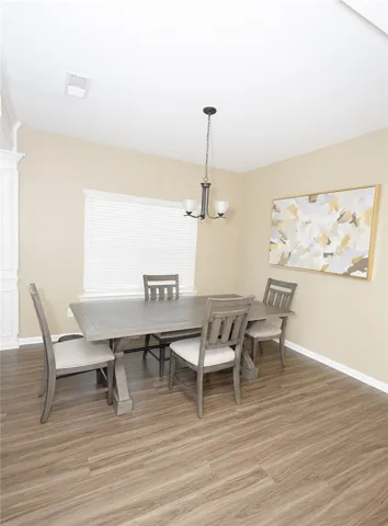 A well-lit dining area offers a seamless flow with durable wood flooring.