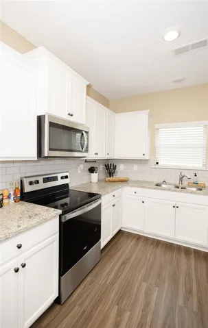 Culinary aspirations come alive in this kitchen featuring abundant cabinetry and sleek countertops.