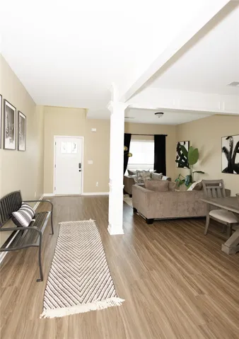 An inviting entry foyer transitions seamlessly to an open-concept living area with durable wood flooring.