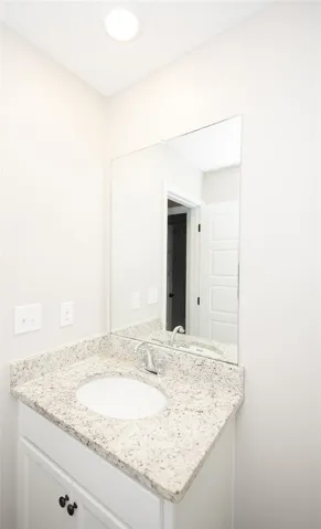 A well-appointed bathroom features a single vanity with granite counters and a large mirror.