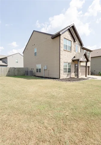 A well-maintained lawn frames this classic residence, featuring a two-car garage and inviting entryway.
