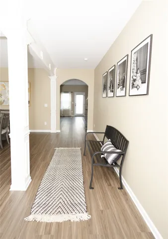 Columned architectural features define this welcoming entry with wood​​‌​​​​‌​​‌‌​‌‌​​​‌‌​‌​‌​‌​​​‌​​ flooring.