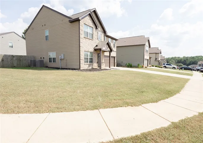 A classic brick and siding two-story home, with a neatly maintained front lawn and attached garage, awaits.