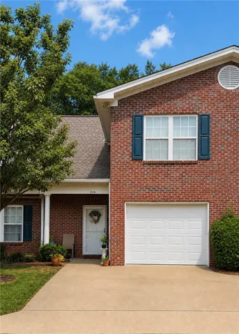 A classic brick exterior welcomes with charming blue shutters and a prominent white garage door.