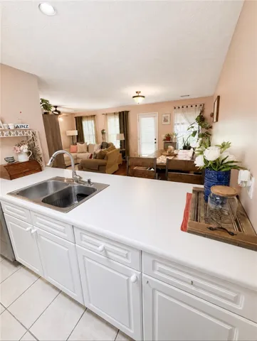 A functional kitchen island flows seamlessly into the inviting living and dining areas, creating an open-concept living space.