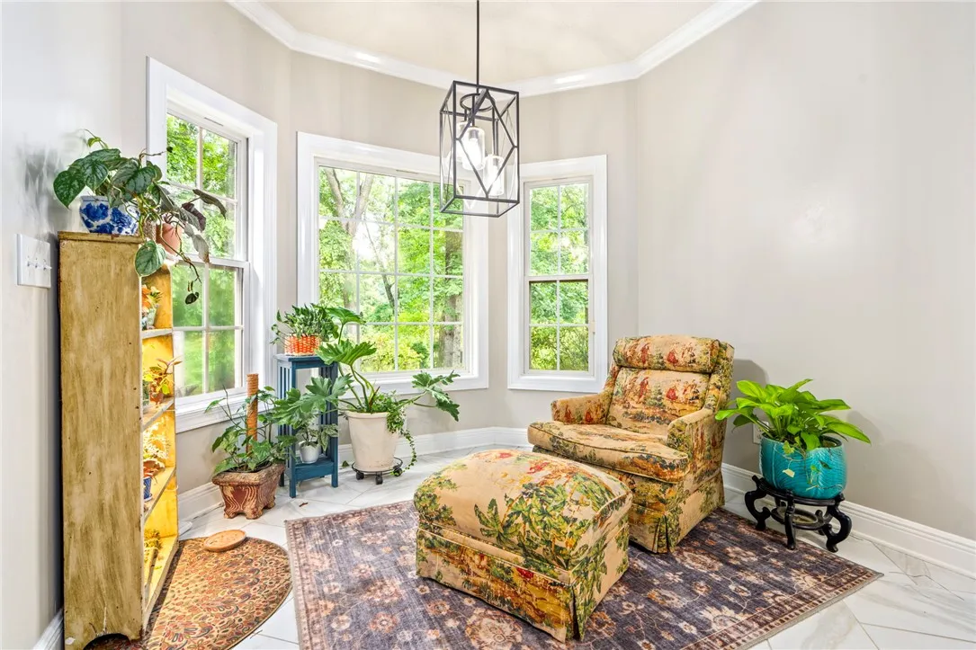 The breakfast room offers abundant natural light and serene views of the surrounding greenery.