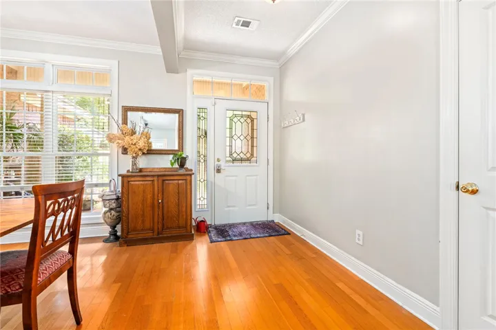 A graceful entry with warm hardwood flooring and transom windows framing the front door.