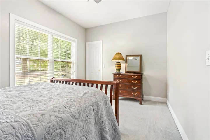 A well-lit bedroom featuring a large window on the front of the home.