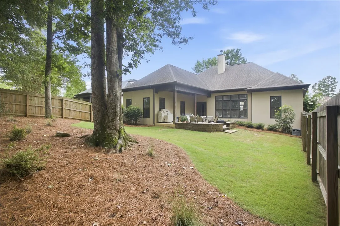 A private, fenced backyard offers a lush lawn and a charming patio for outdoor enjoyment.