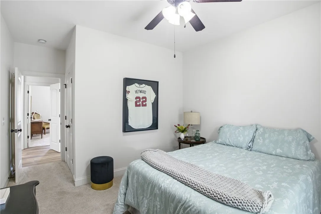 A comfortable bedroom features carpeted flooring and a convenient ceiling fan.