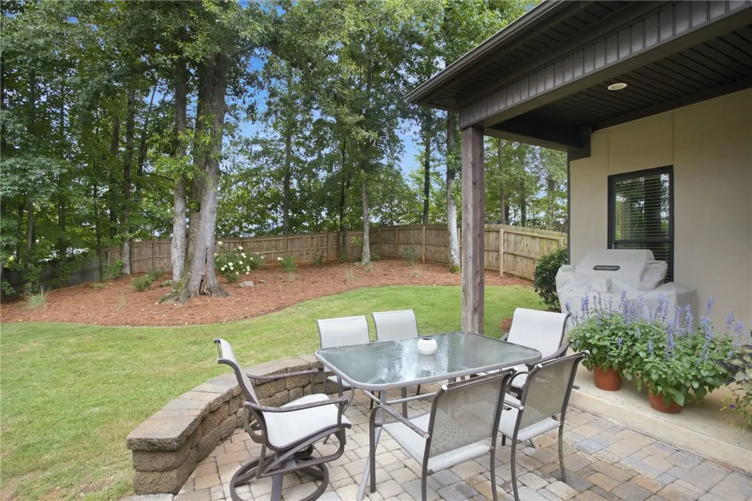 A private backyard oasis features a paved patio perfect for outdoor dining and entertaining.