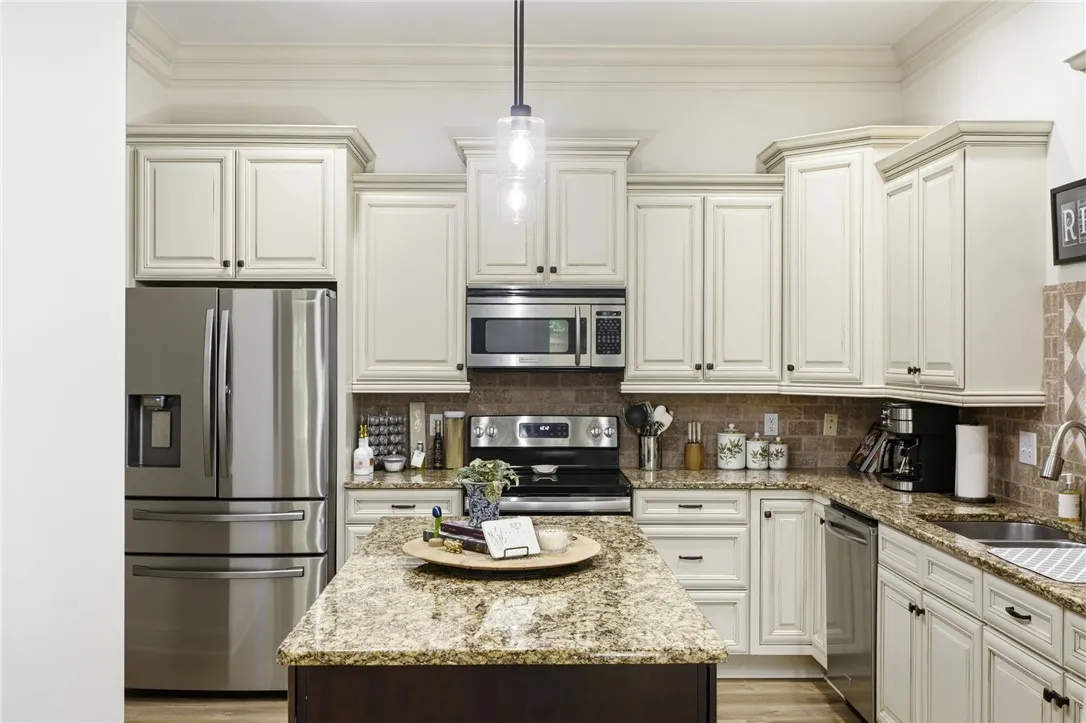 A chef's kitchen showcasing ample cabinetry, granite counters, and stainless steel appliances.