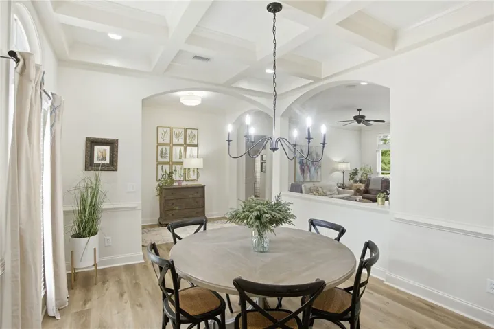 An elegant coffered ceiling and a classic chandelier elevate this inviting dining space.