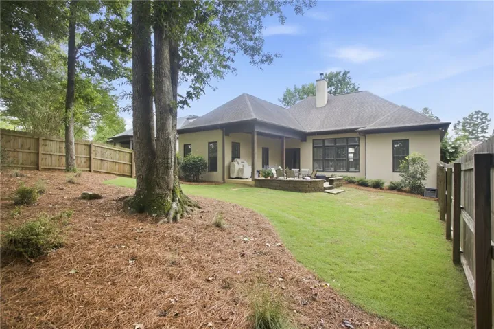 A private, fenced backyard offers a lush lawn and a charming patio for outdoor enjoyment.