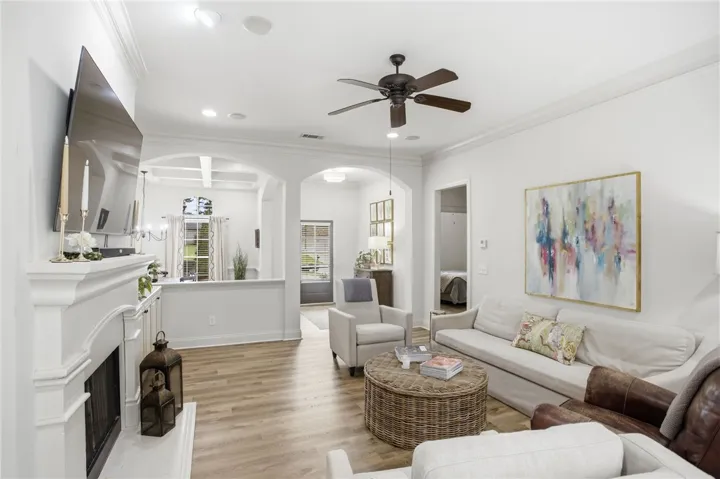 Natural light illuminates this inviting living space, featuring rich hardwood flooring and a cozy fireplace with an elegant white mantel.