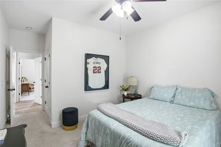 A comfortable bedroom features carpeted flooring and a convenient ceiling fan.