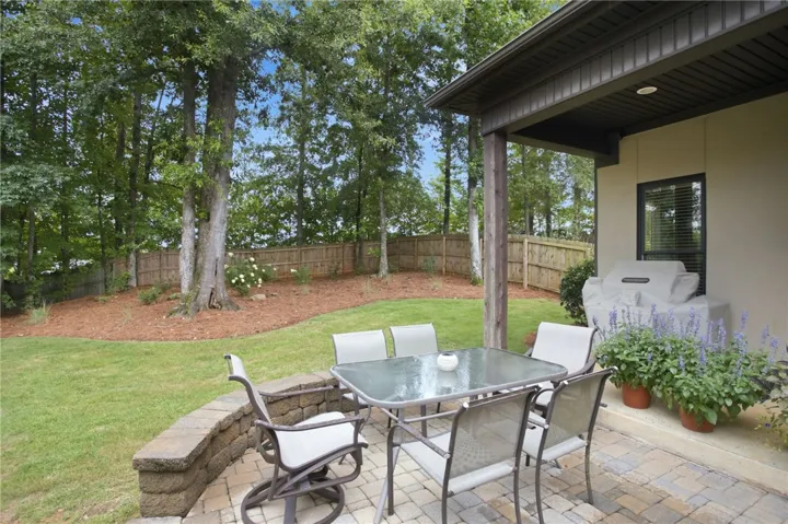 A private backyard oasis features a paved patio perfect for outdoor dining and entertaining.