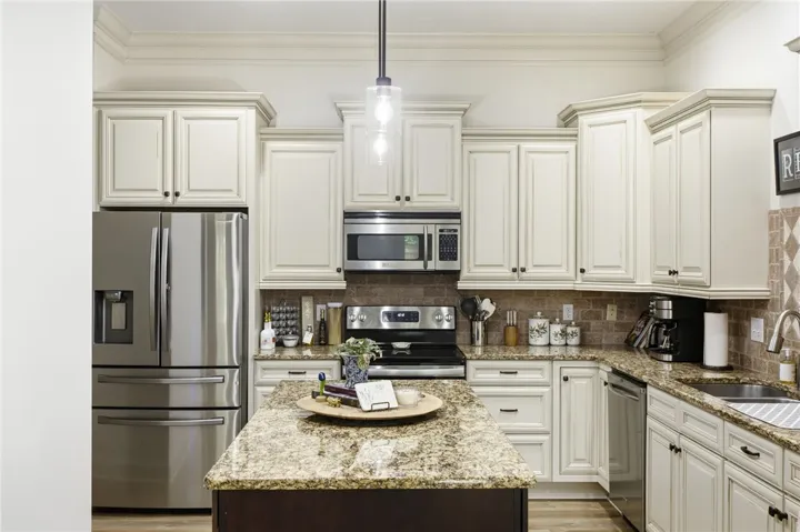 A chef's kitchen showcasing ample cabinetry, granite counters, and stainless steel appliances.