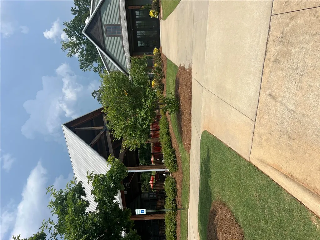 Well-maintained landscaping and concrete pathways lead to inviting, modern-rustic buildings.