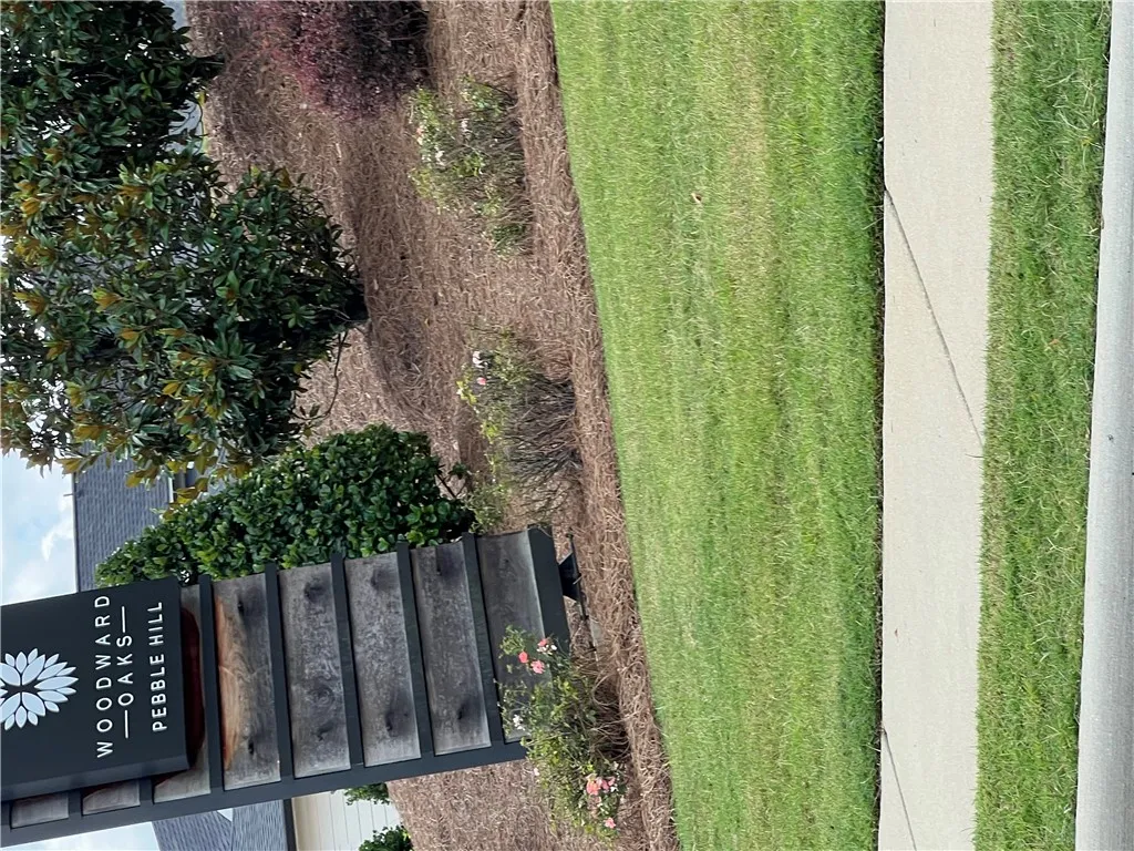 Manicured green spaces line a welcoming sidewalk, offering a pleasant community entry.