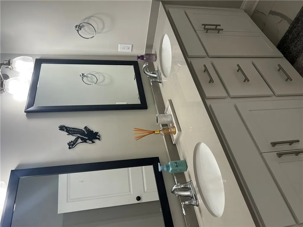 Dual vanities with sleek countertops offer practical elegance in this well-appointed bathroom.