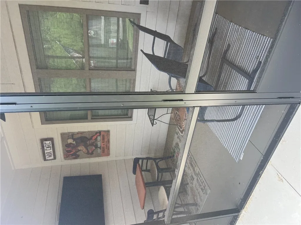 Enjoy outdoor living and dining on this enclosed patio, offering serene views of the surrounding greenery. Custom screening and ceiling fan too!