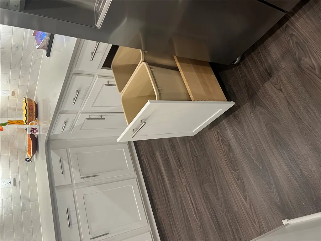 Functional kitchen with stylish wood flooring and ample cabinetry for storage.