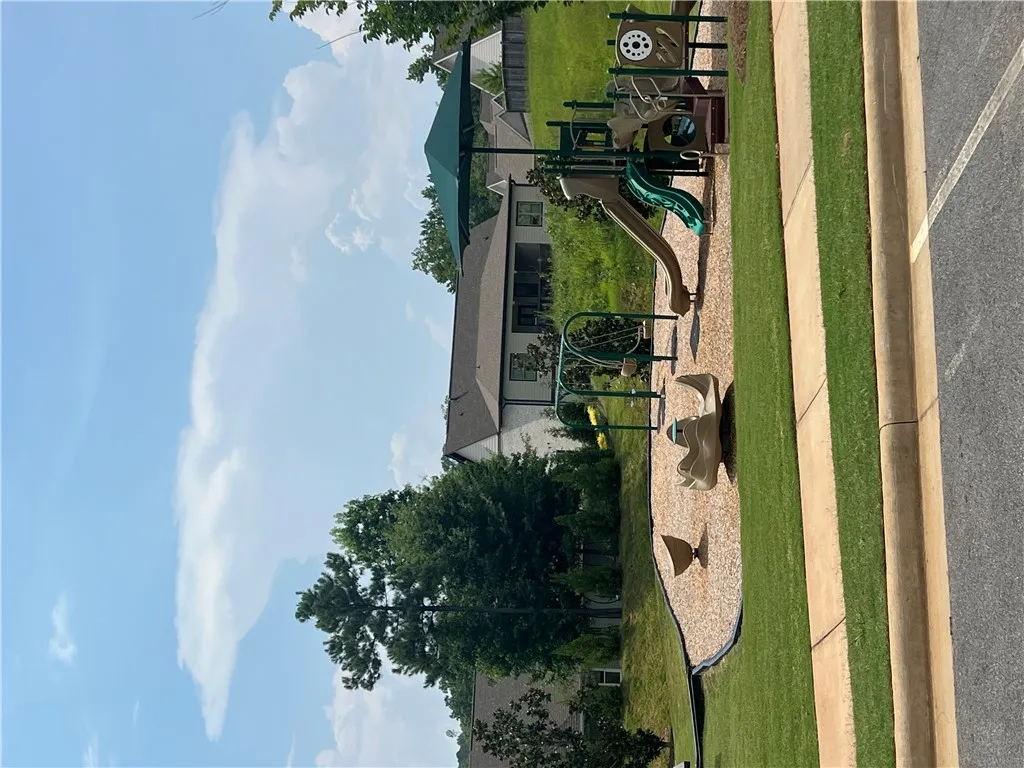 A community playground awaits, featuring modern equipment set on a wood chip surface, ready for recreation.