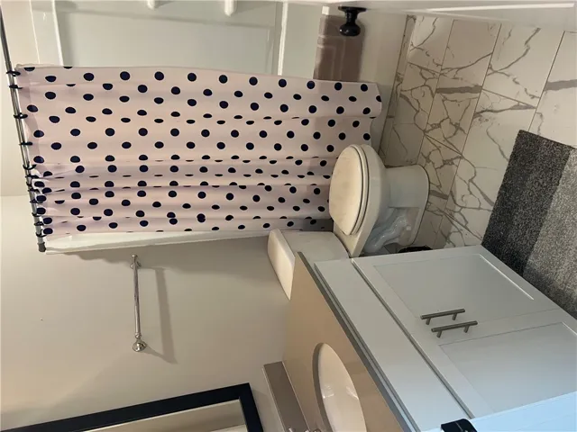 A 2nd clean and functional bathroom features a shower, toilet, and vanity with ample storage.