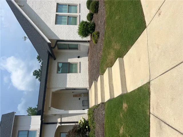 White brick exterior with neatly manicured landscaping offers inviting curb appeal.