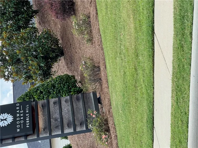 Manicured green spaces line a welcoming sidewalk, offering a pleasant community entry.