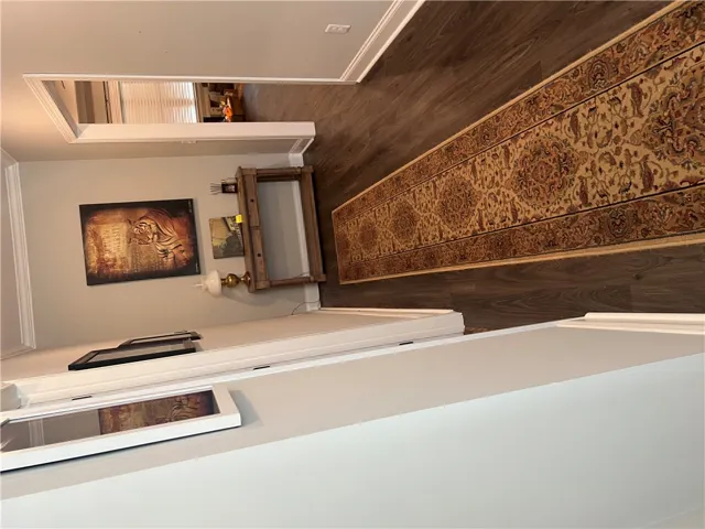 Rich wood flooring and a classic runner define this inviting hallway. 9ft ceilings are another great feature!