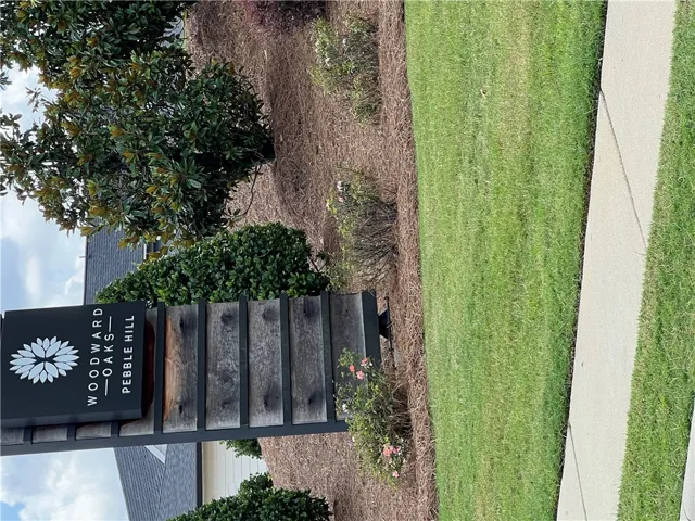 Manicured lawn and natural landscaping welcome residents to this desirable community.