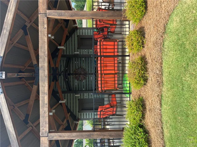 A grand outdoor pavilion with exposed timber framing provides a welcoming community gathering space.