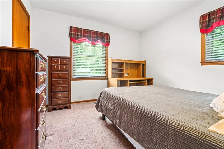 A well-lit bedroom with carpeting and a bed, perfect for peaceful repose.
