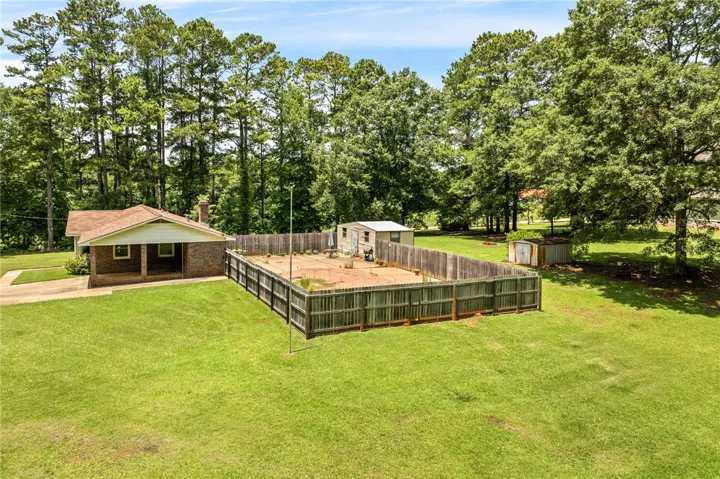 Mature trees surround this cozy brick ranch with a private, fenced backyard.